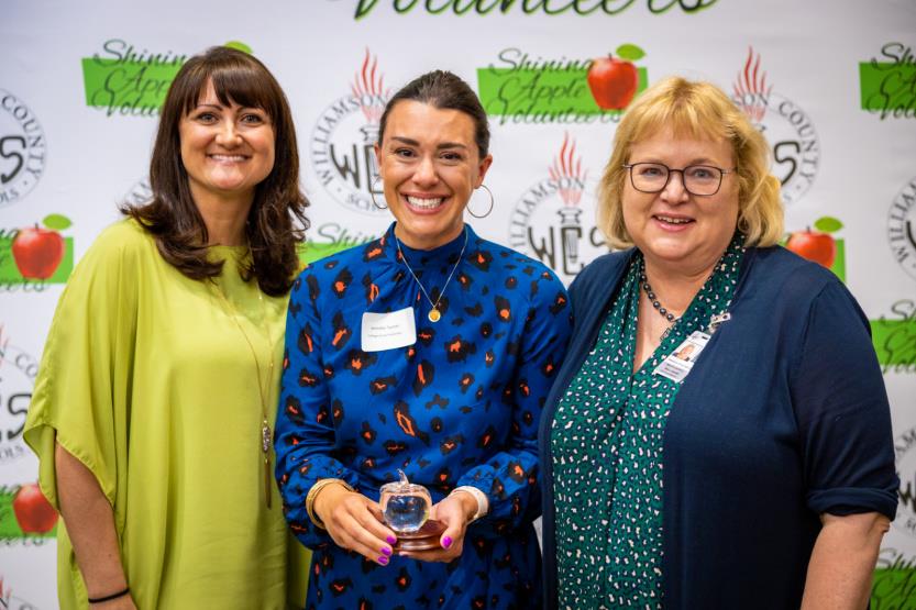 Three women pose for a photo